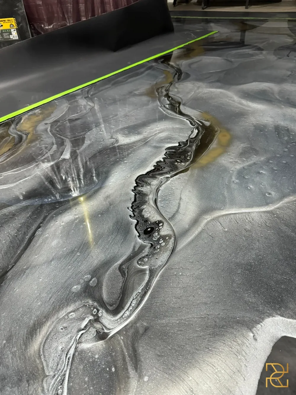 Zwart water onder het messing, epoxy gietvloerproject van Rocco Resin