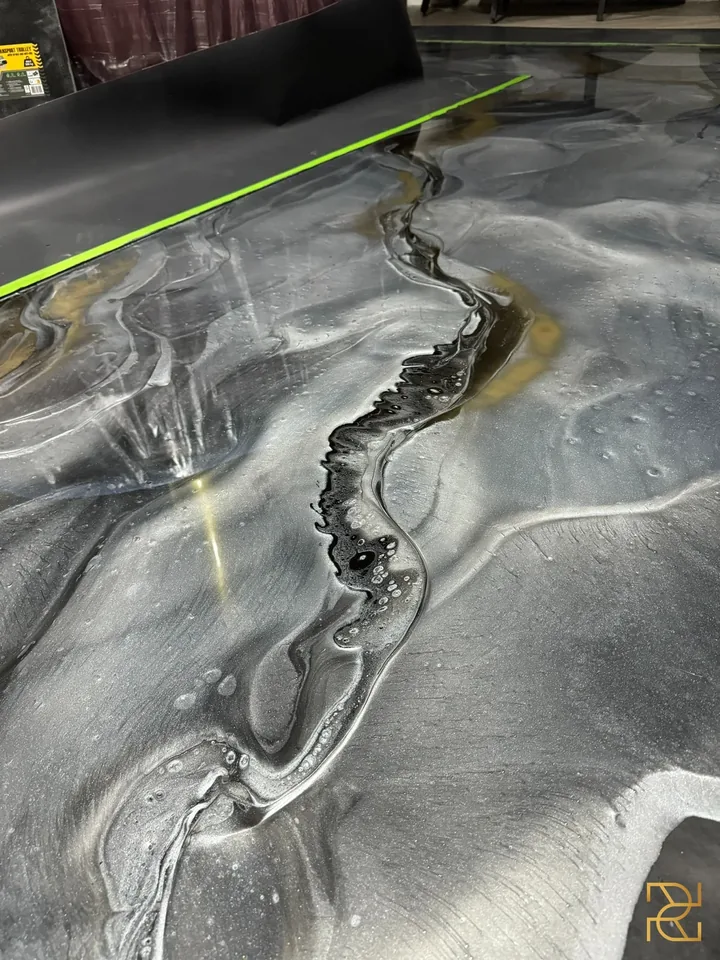 Zwart water onder het messing, epoxyvloer van Rocco Resin