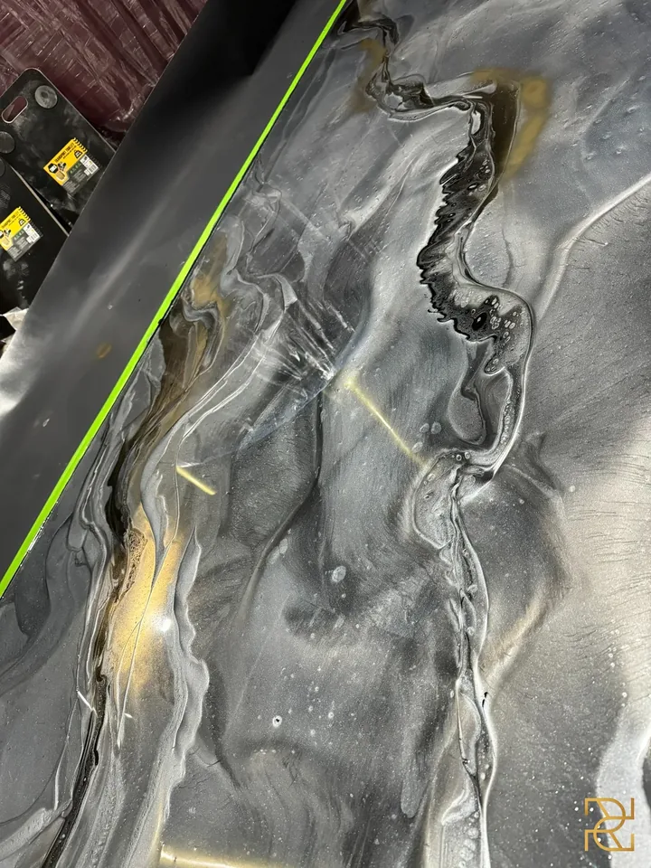 Zwart water onder het messing, epoxyvloer van Rocco Resin