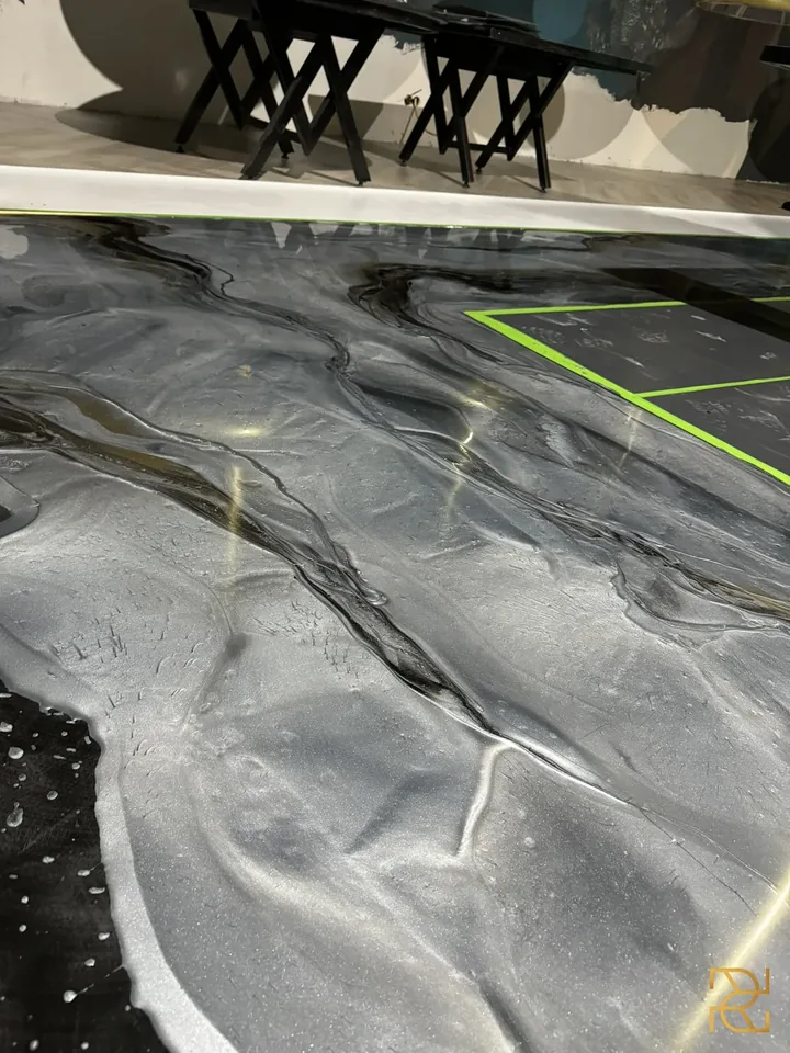 Zwart water onder het messing, epoxyvloer van Rocco Resin