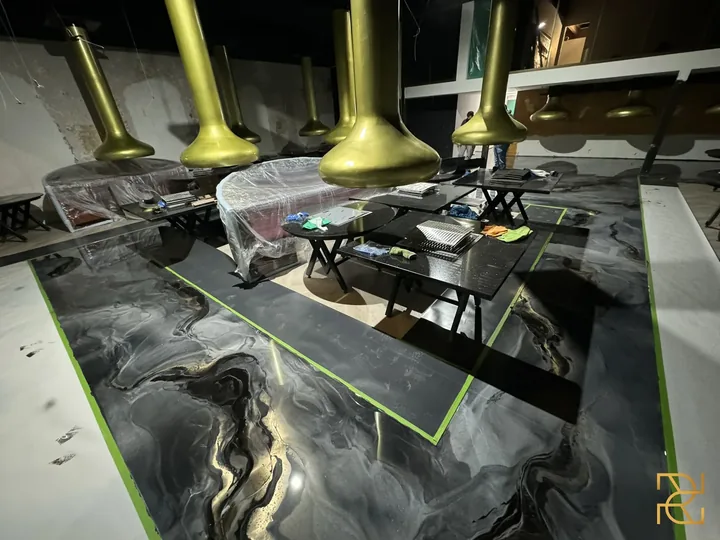 Zwart water onder het messing, epoxyvloer van Rocco Resin